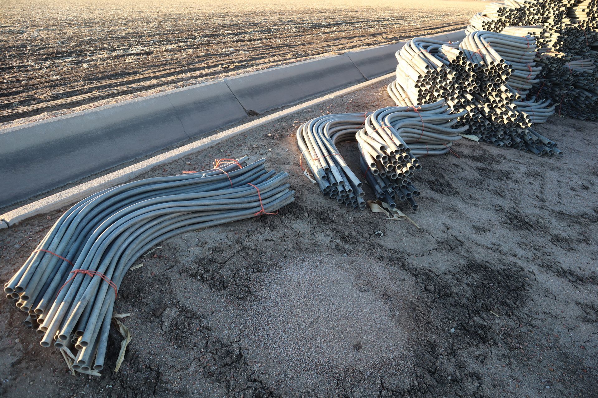 A bunch of metal pipes are laying on the ground