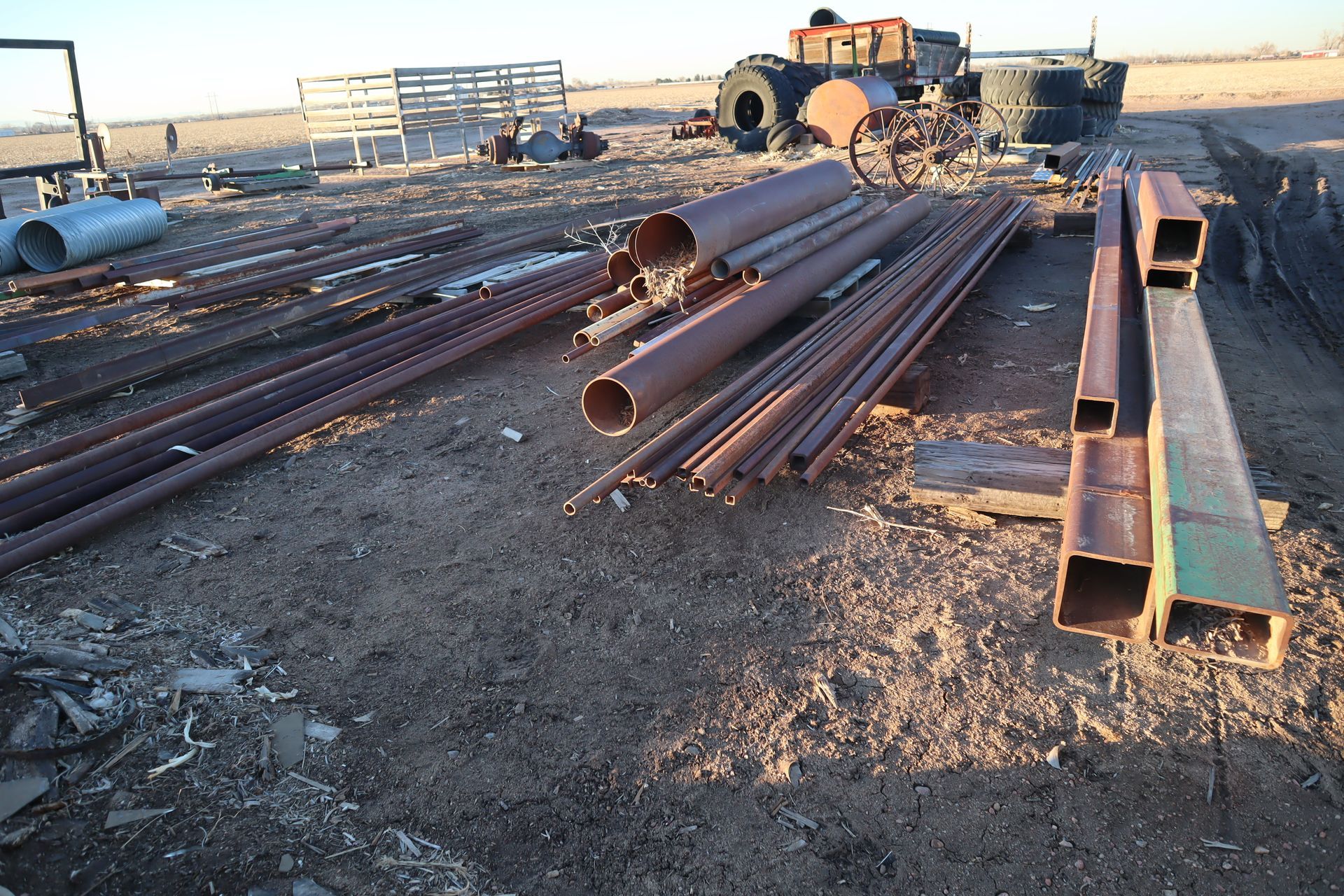 A bunch of rusty metal pipes are laying on the ground