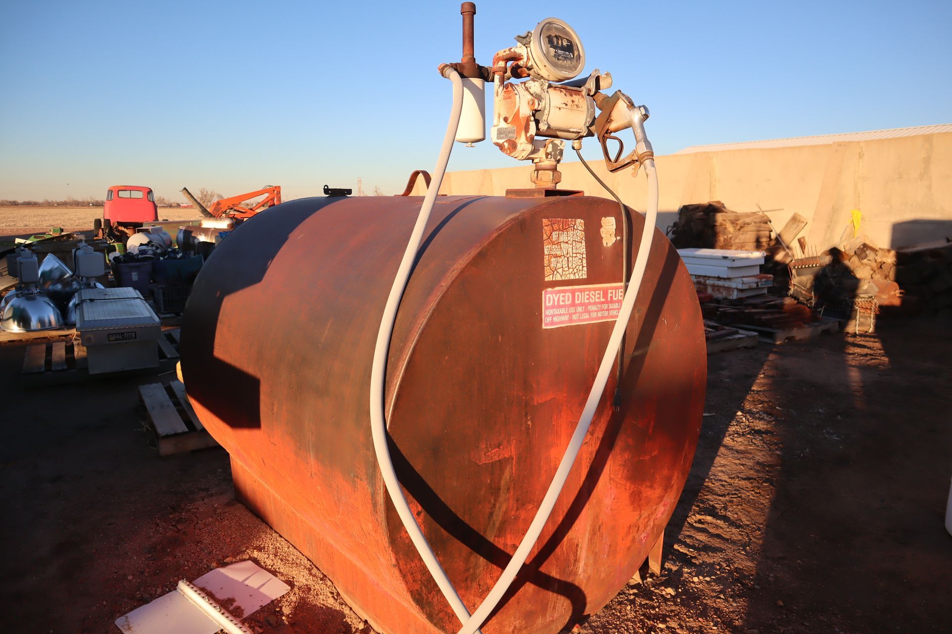A large rusty tank with a hose attached to it.