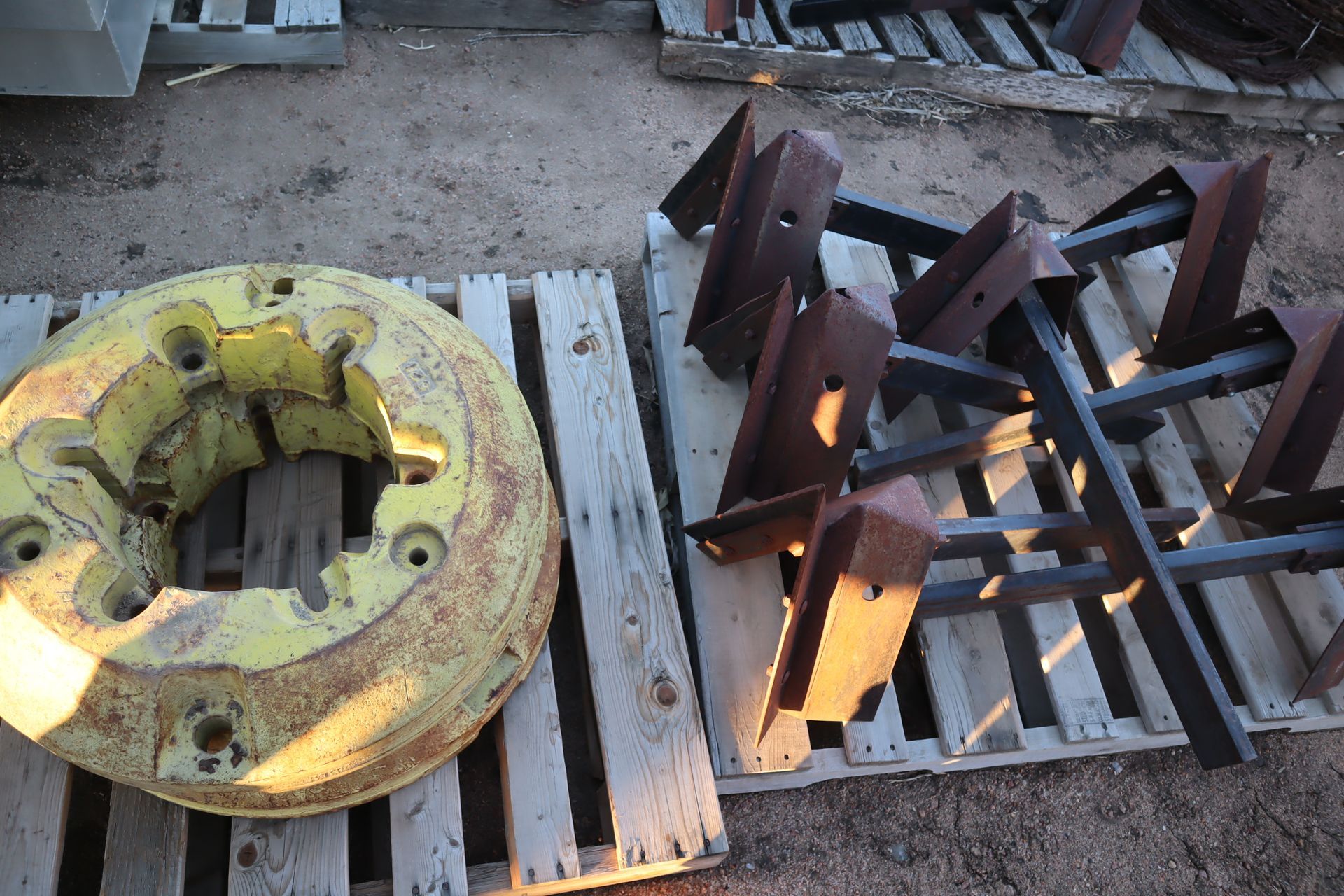 A tractor wheel is sitting on a wooden pallet