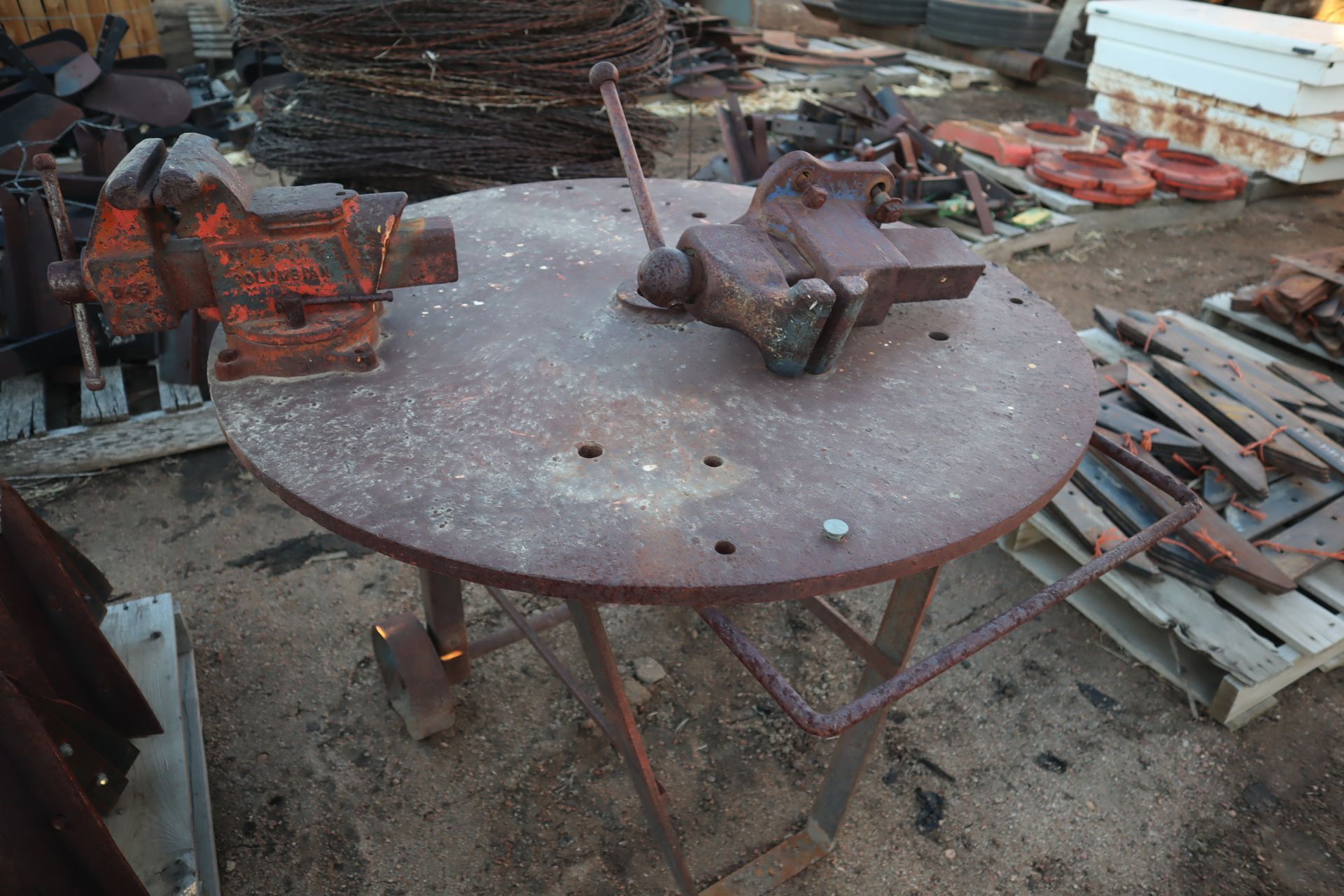 A round table with a vise on top of it