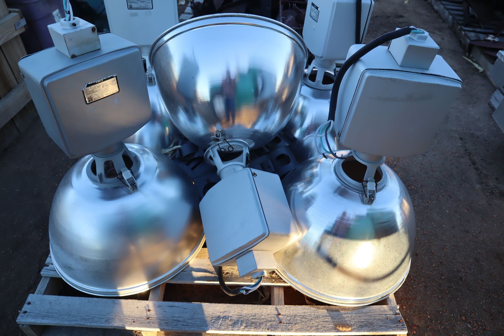 A bunch of silver bowls are sitting on a wooden pallet