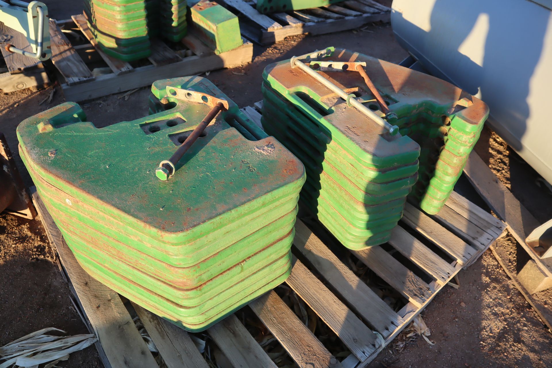 A stack of green weights sitting on top of a wooden pallet.