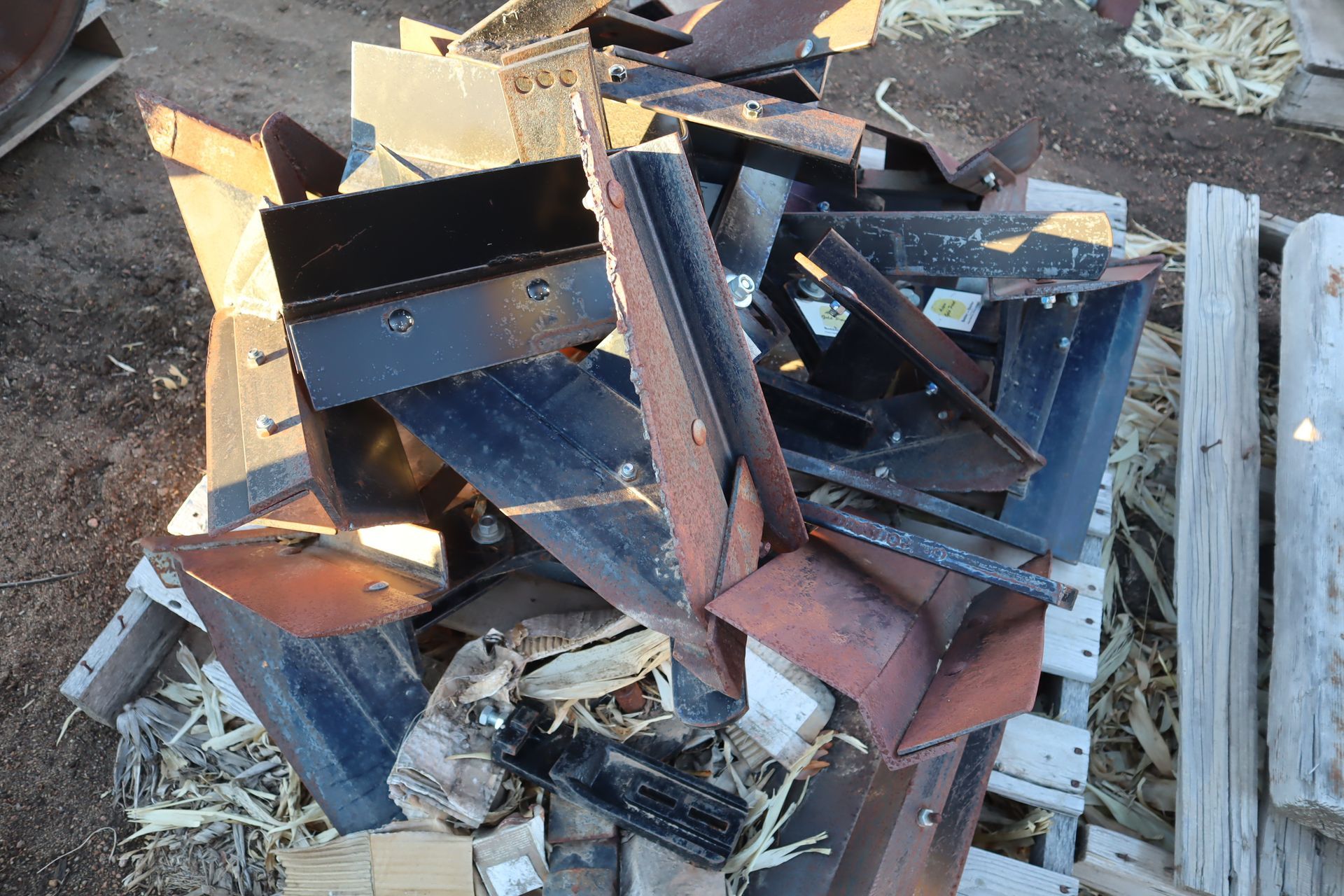A pile of scrap metal is sitting on top of a wooden pallet.