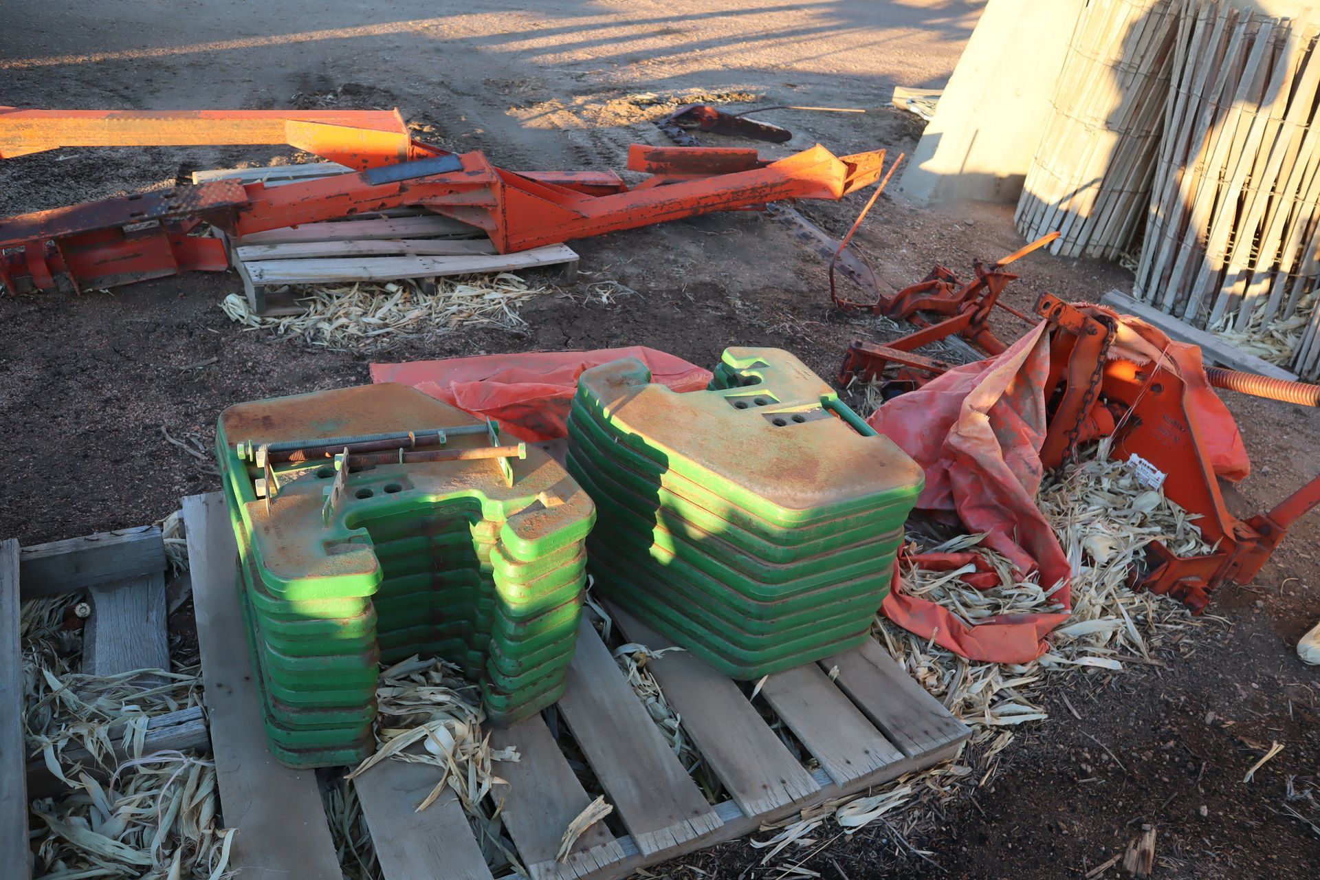 A pile of green weights sitting on top of a wooden pallet.