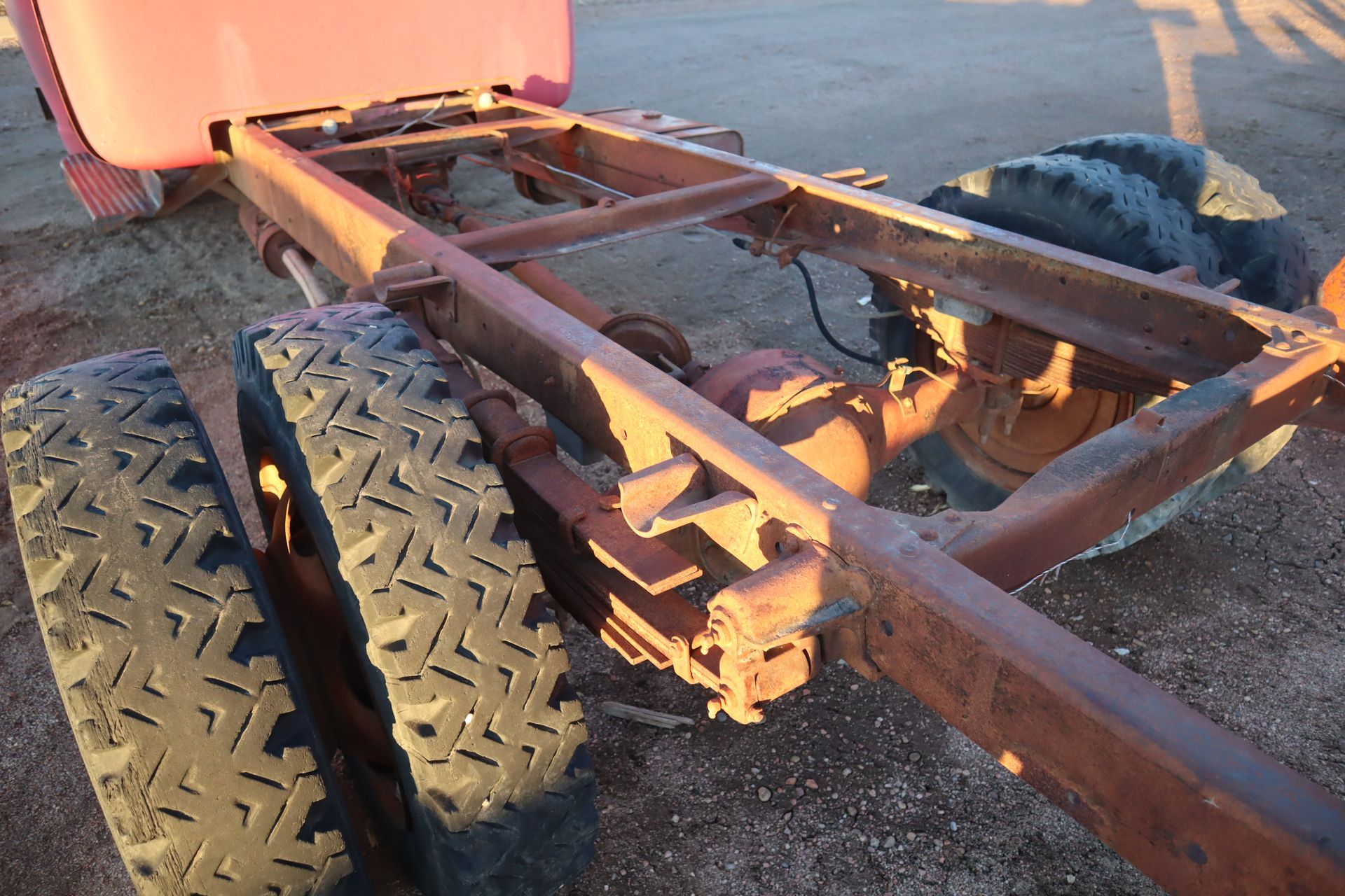 A red truck with a rusty frame and tires