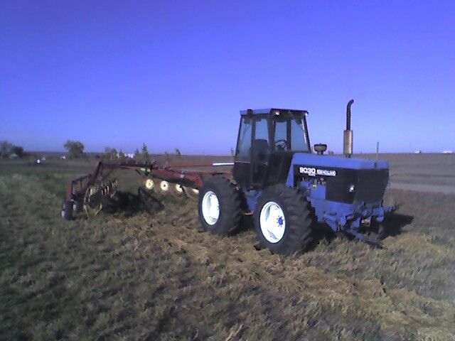 A blue ford tractor is parked in a field