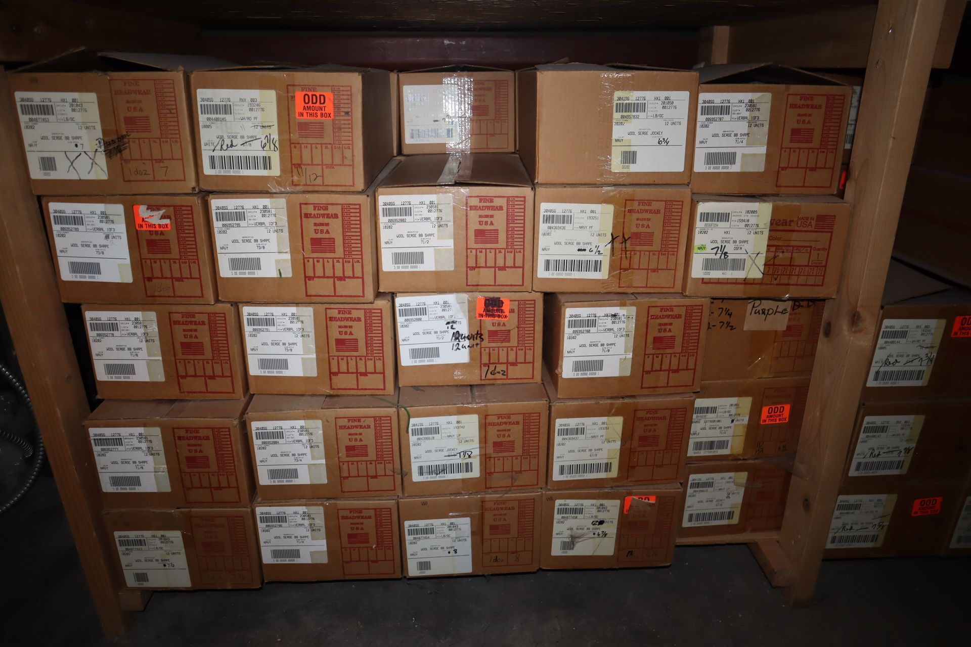 Cardboard boxes stacked on wooden shelving. Boxes have shipping labels.