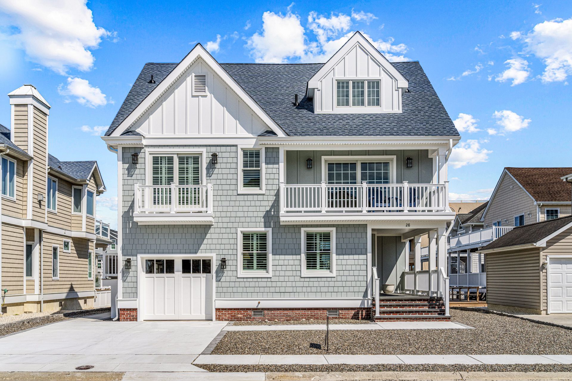 A large house with a blue roof and white trim is for sale.