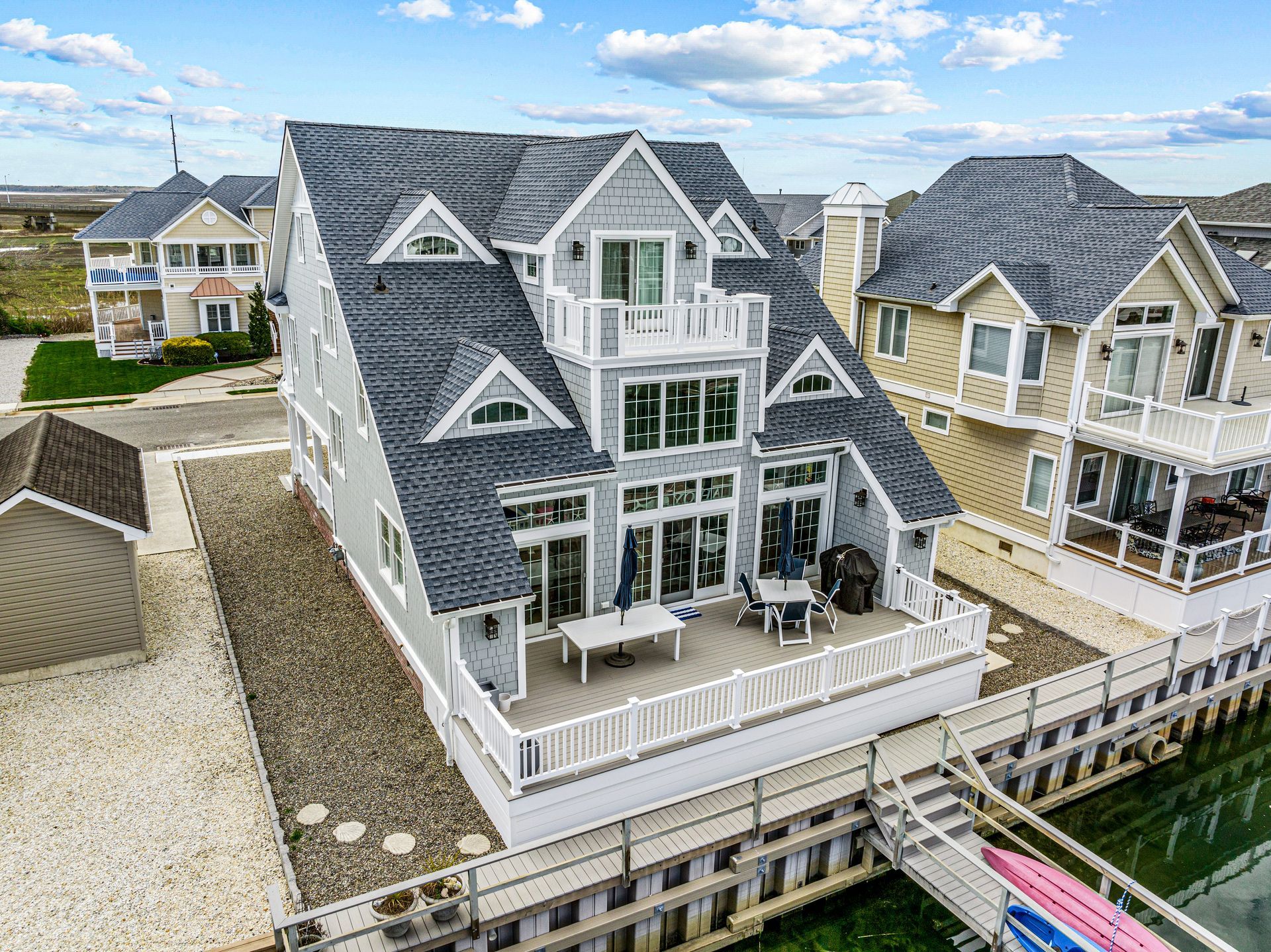 An aerial view of a large house next to a body of water.