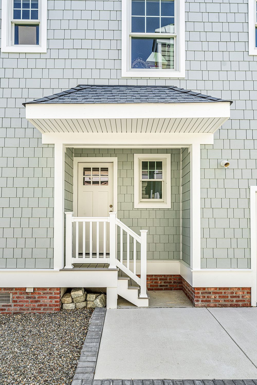 a blue house with a white porch and stairs
