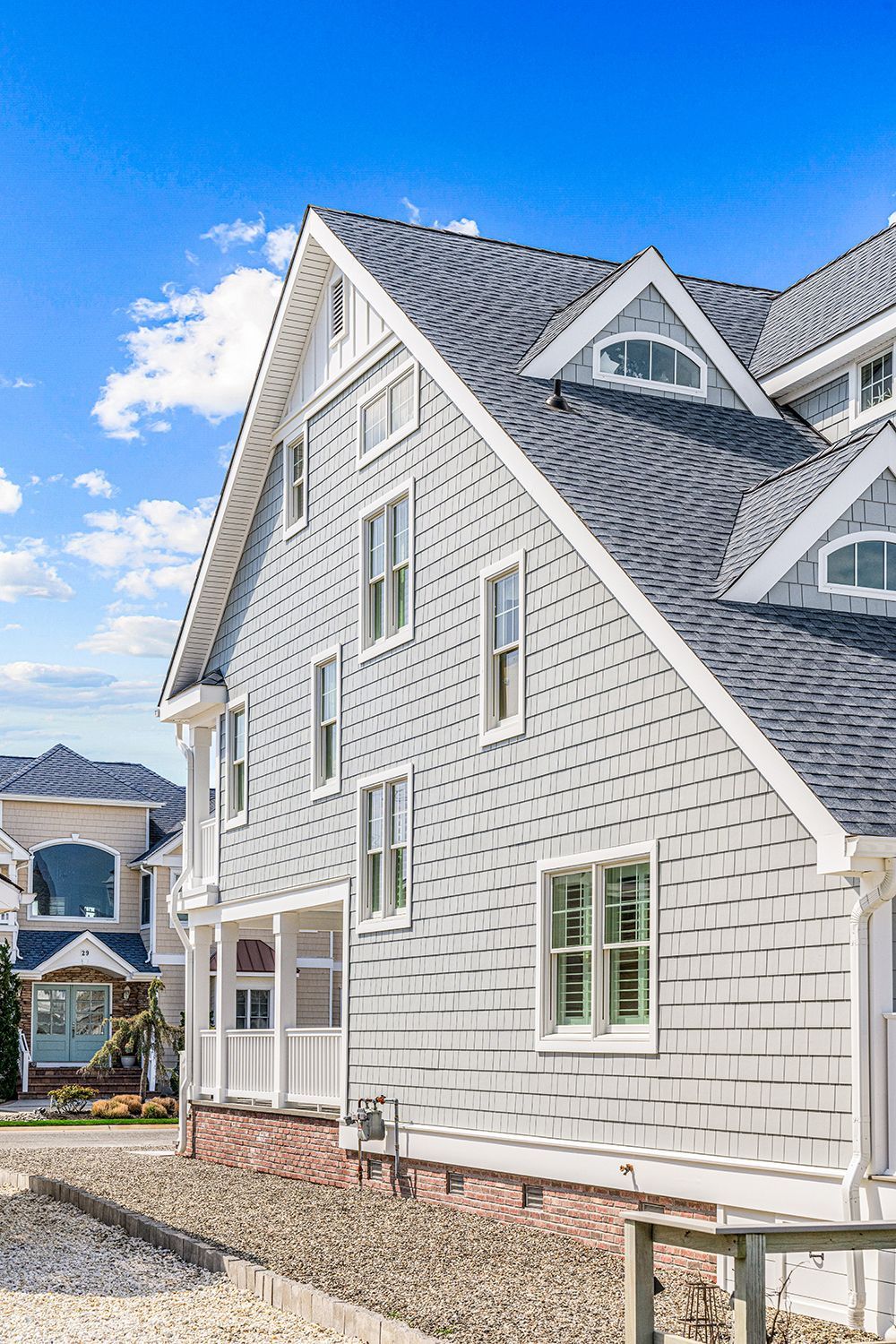 a large white house with a gray roof and a lot of windows