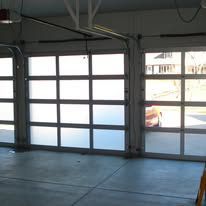 A garage door with a lot of windows and a car parked in it.
