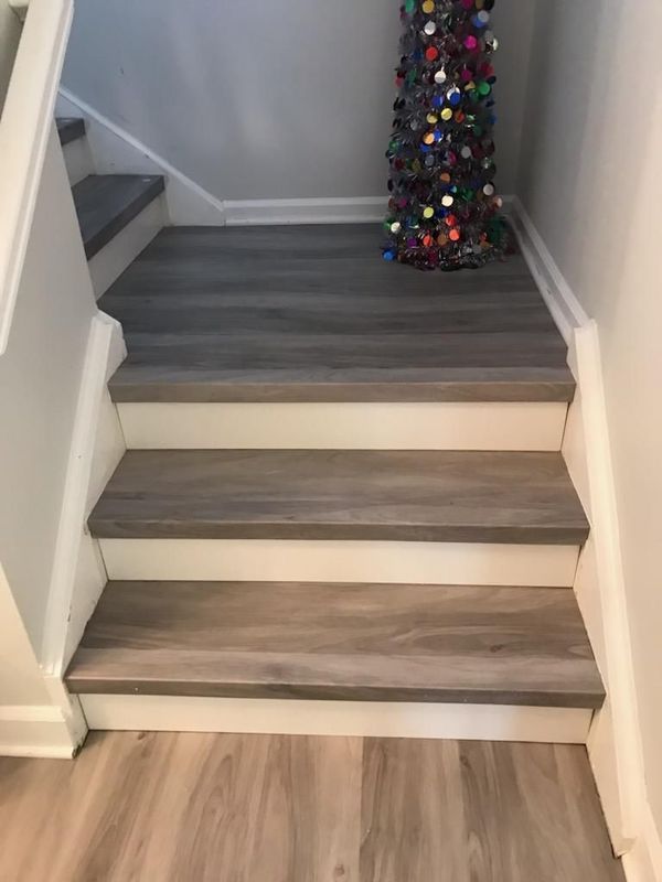 Wooden stair treads with white risers and trim, leading up to a landing.