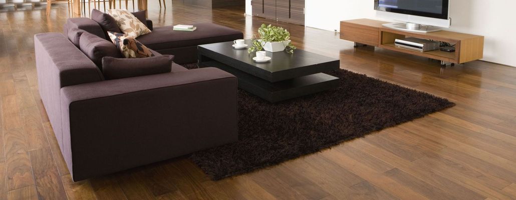 Modern living room with a purple sofa, black coffee table, and wooden floor