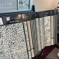 Tile samples in various colors and patterns displayed on a rack, indoors.