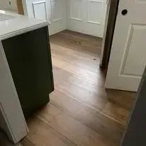 Hardwood floor, green cabinet, white countertop in a room with white doors and a door frame.