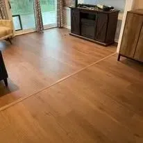 Wooden floor with visible seam. The room includes a cabinet, window, and door.