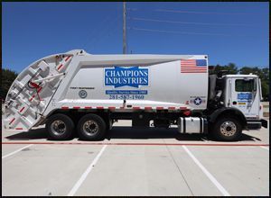 A garbage truck from Champions Industries is parked in a parking lot