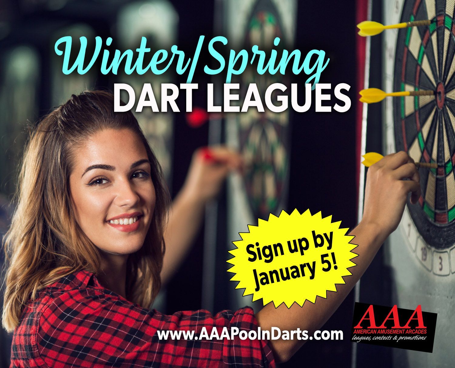 A woman is holding a dart in front of a dart board.