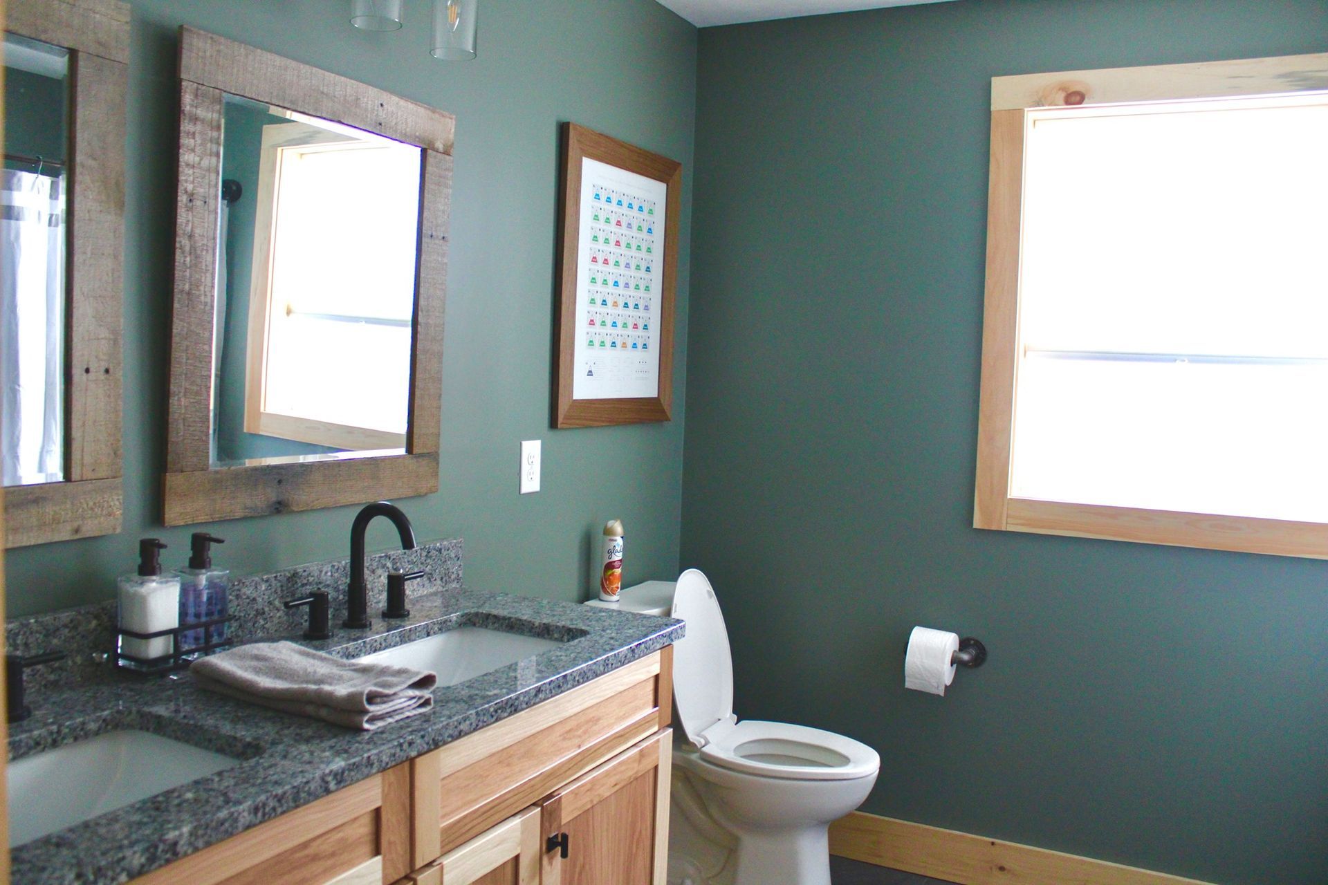 A bathroom with a toilet a sink and two mirrors
