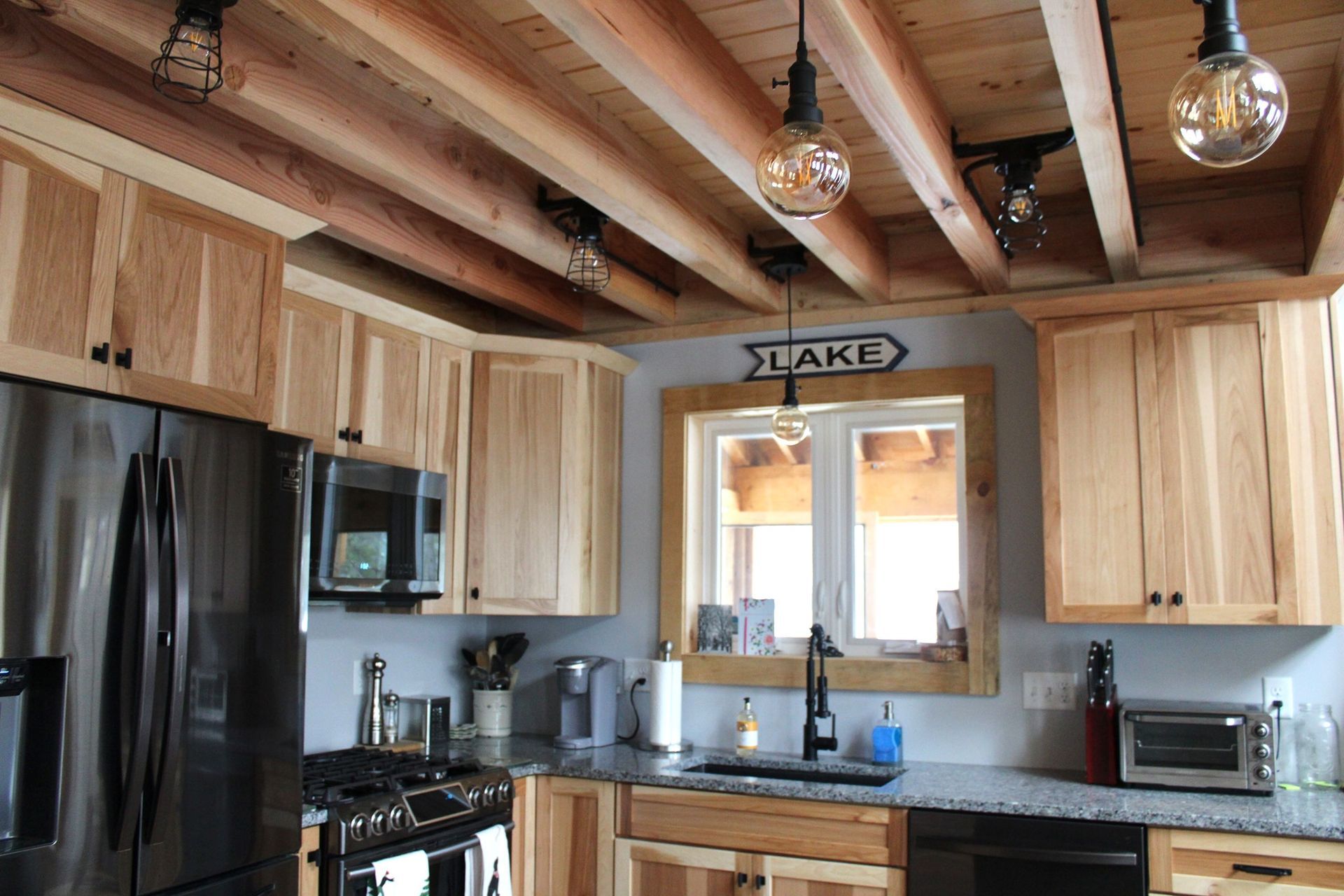 A kitchen with wooden cabinets and a sign that says lake