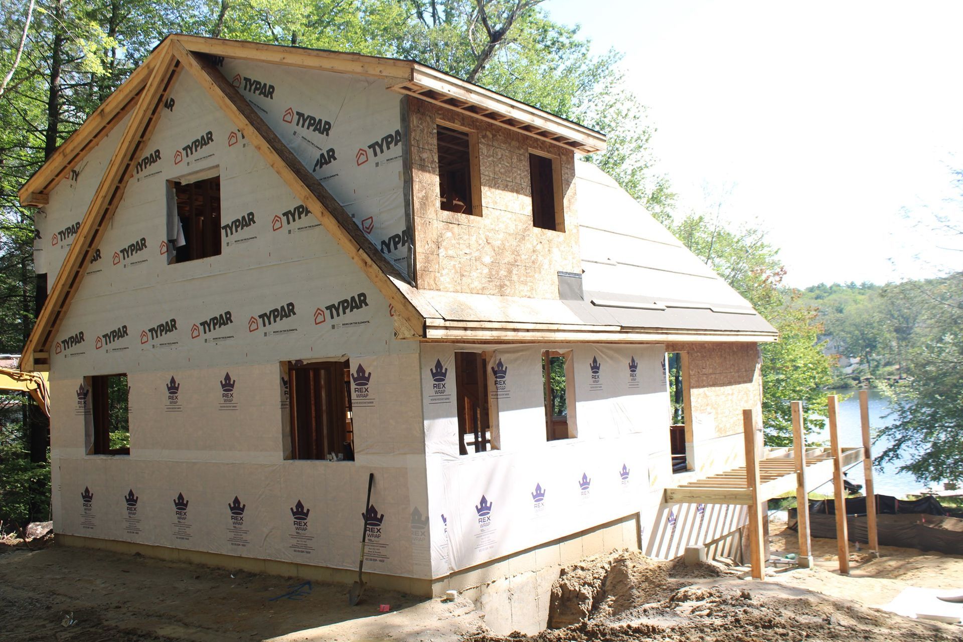 A house is being built next to a body of water.