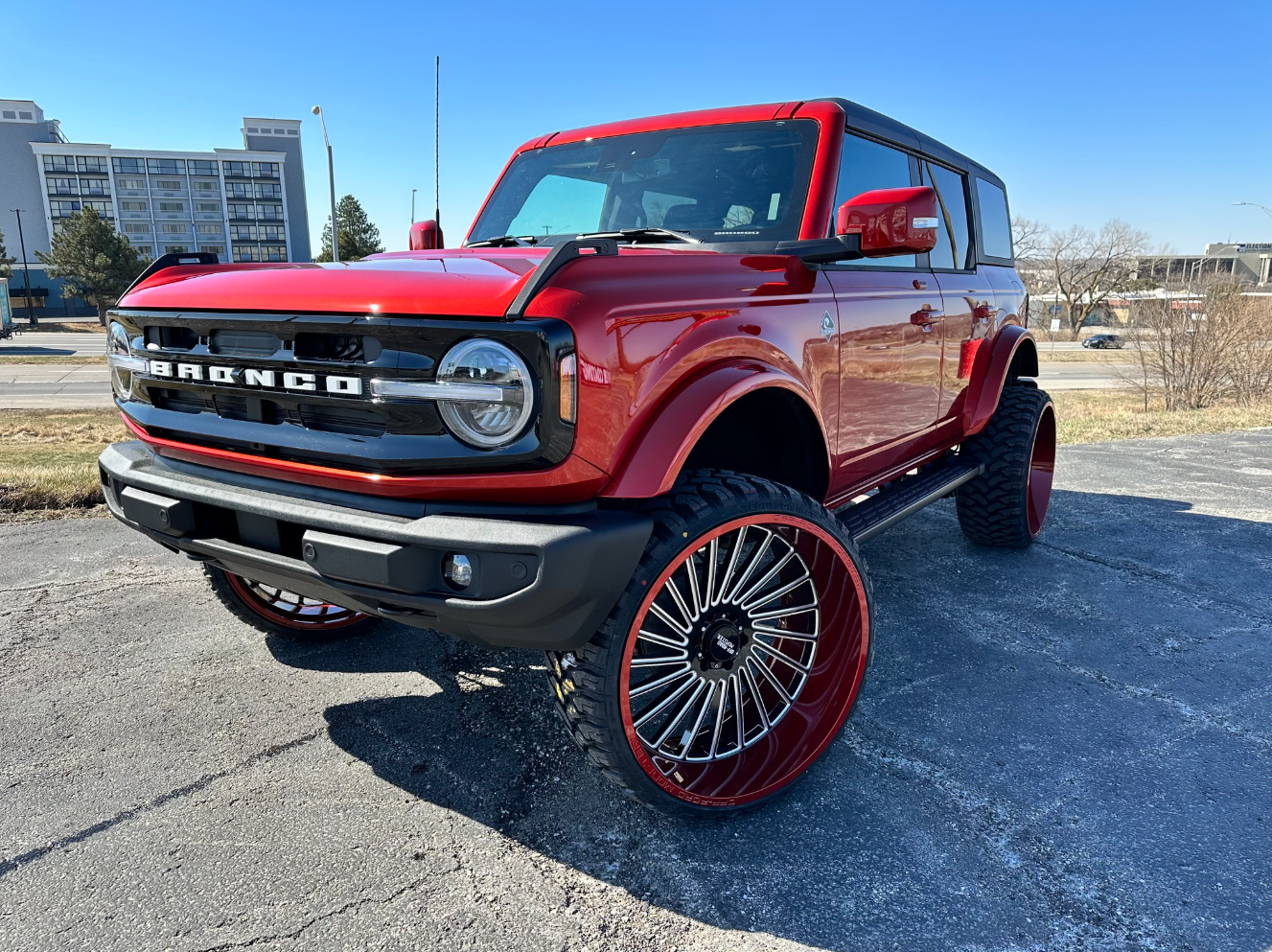White sports car with black wheels and red brake calipers parked outside a building.