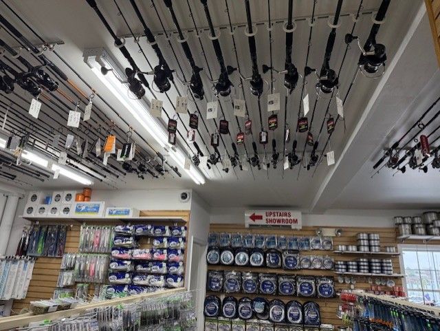 A fishing store with lots of fishing rods hanging from the ceiling.