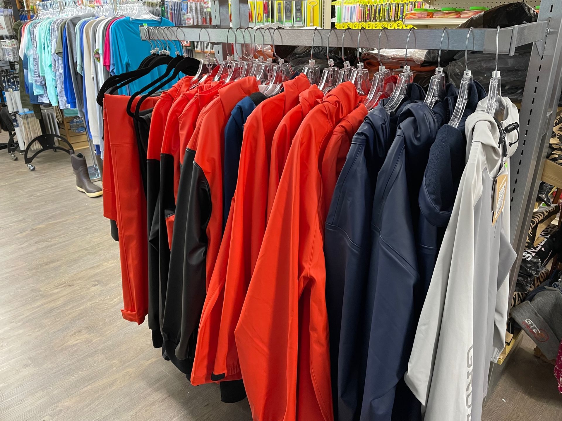 A row of jackets hanging on a rack in a store.