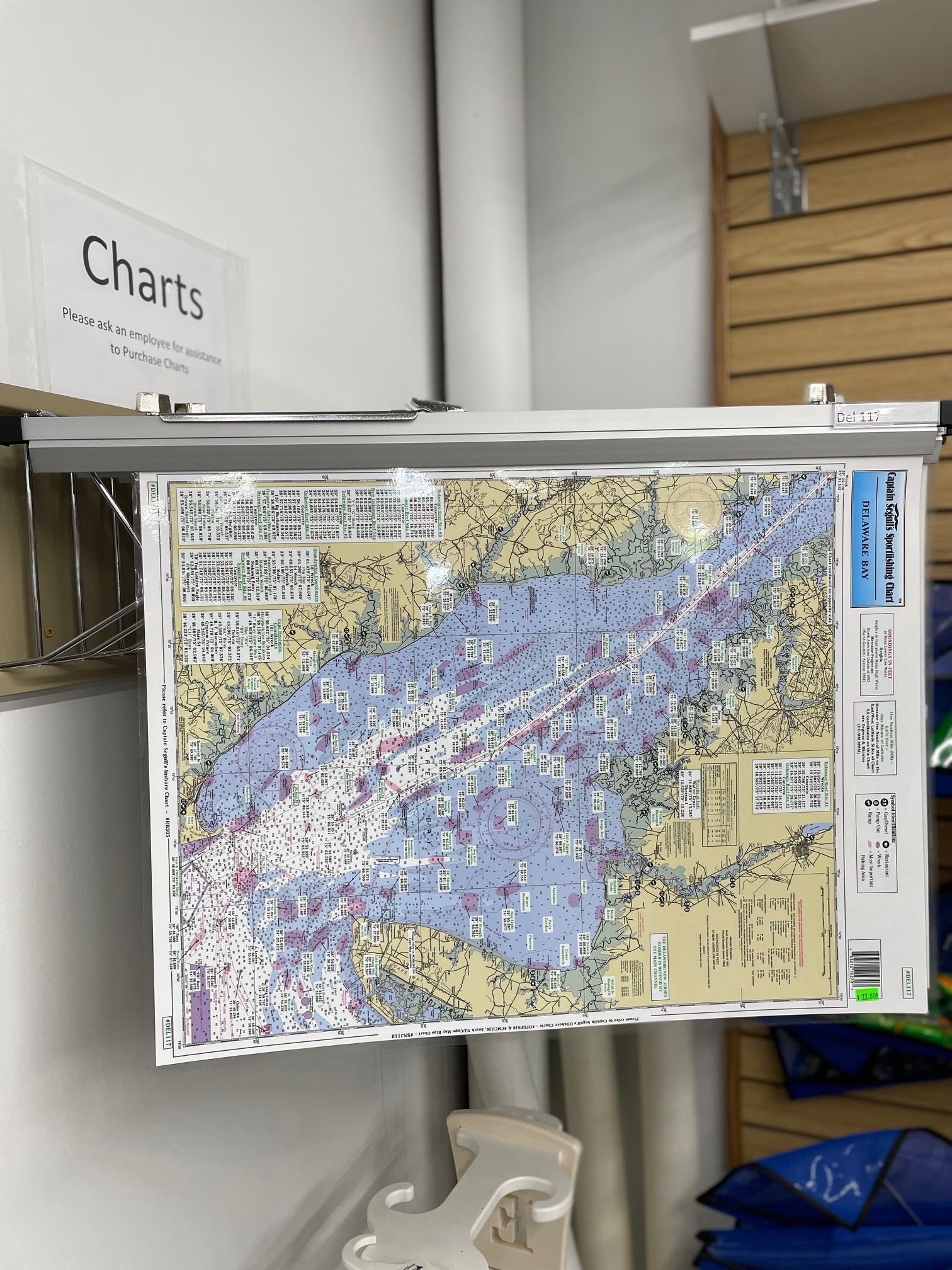 A large map is hanging on a wall next to a sign that says charts