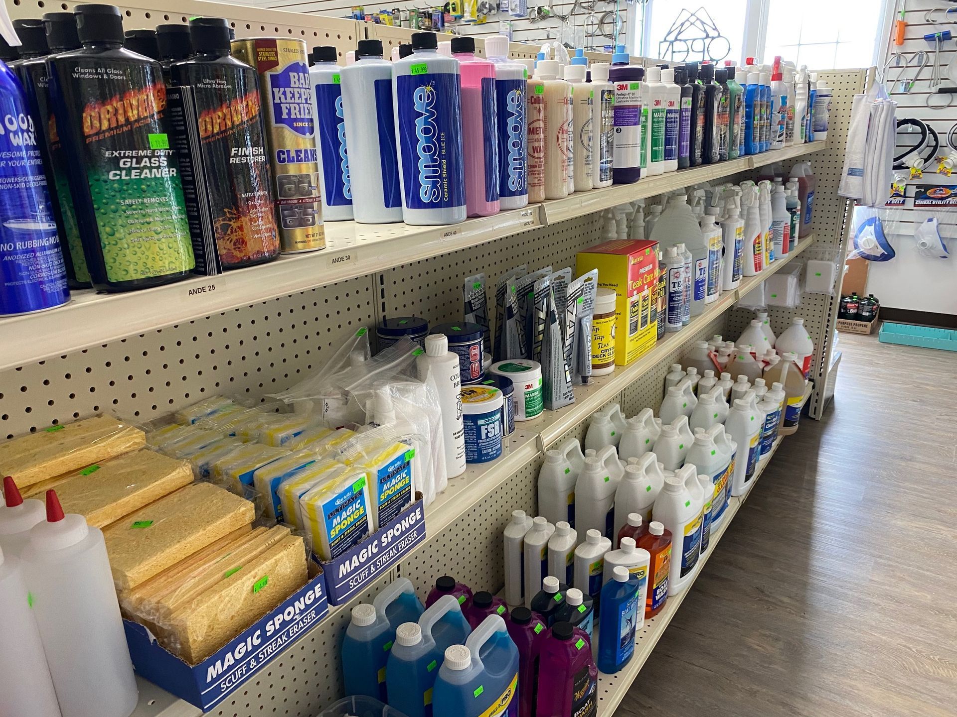 A store shelf filled with lots of bottles and sponges.
