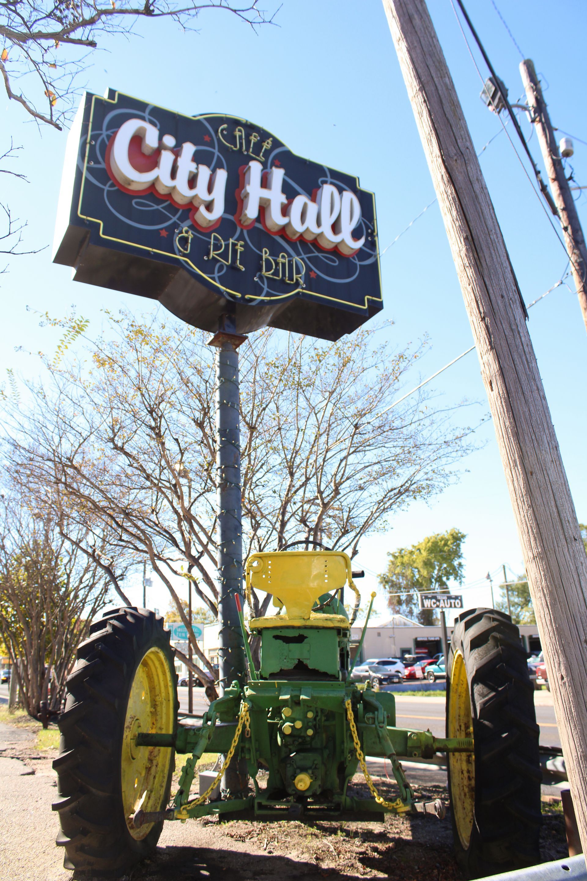 A tractor sits under a city hall sign