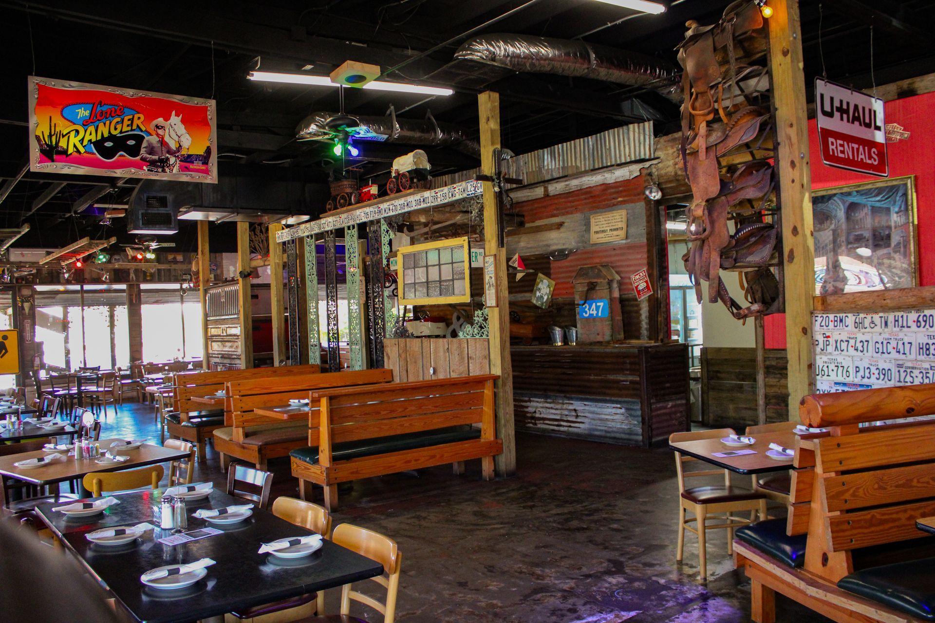 A restaurant with tables and chairs and a sign that says u-haul hanging from the ceiling.