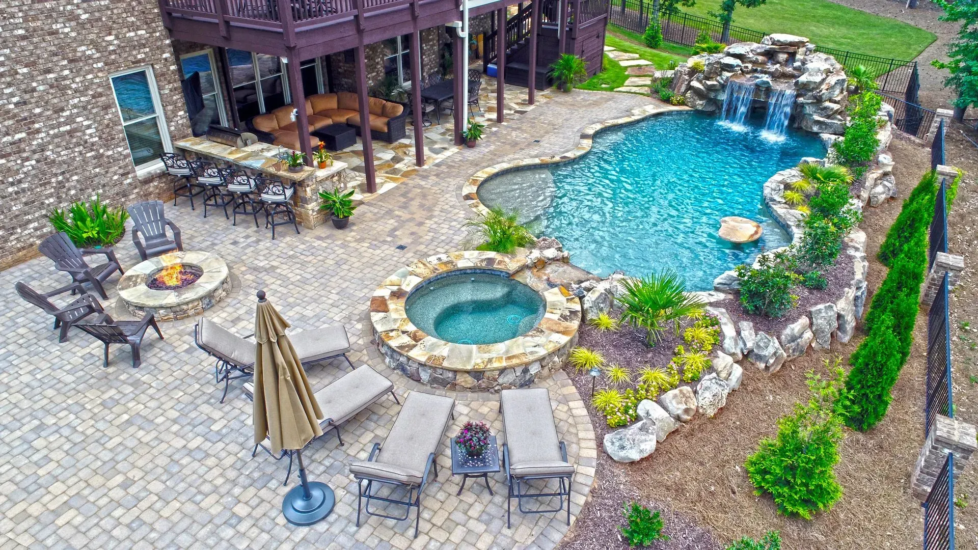 Backyard patio with pool, spa, and fire pit surrounded by landscaping.