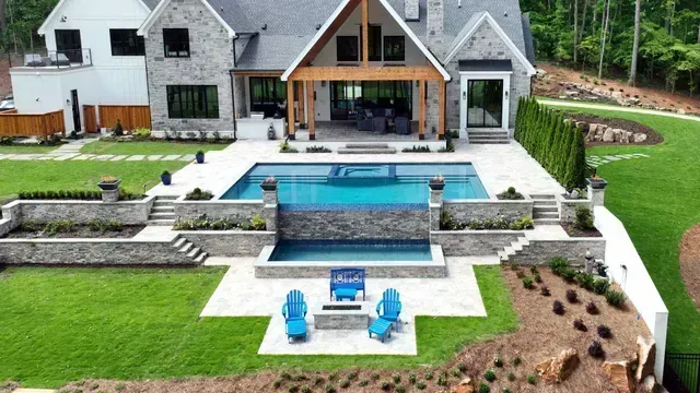 Luxury home exterior with pool, stonework, and manicured landscaping.