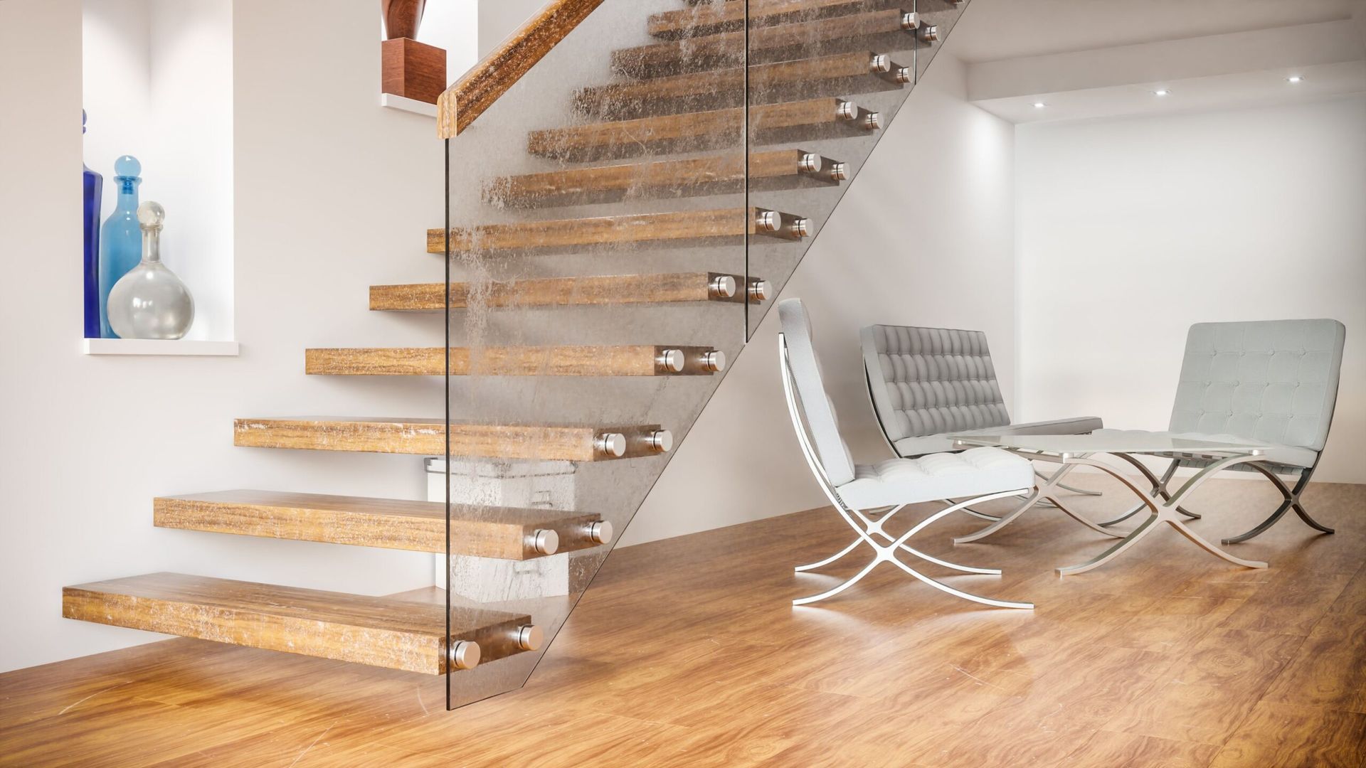 Modern interior with floating wooden staircase and two silver chairs on a hardwood floor.