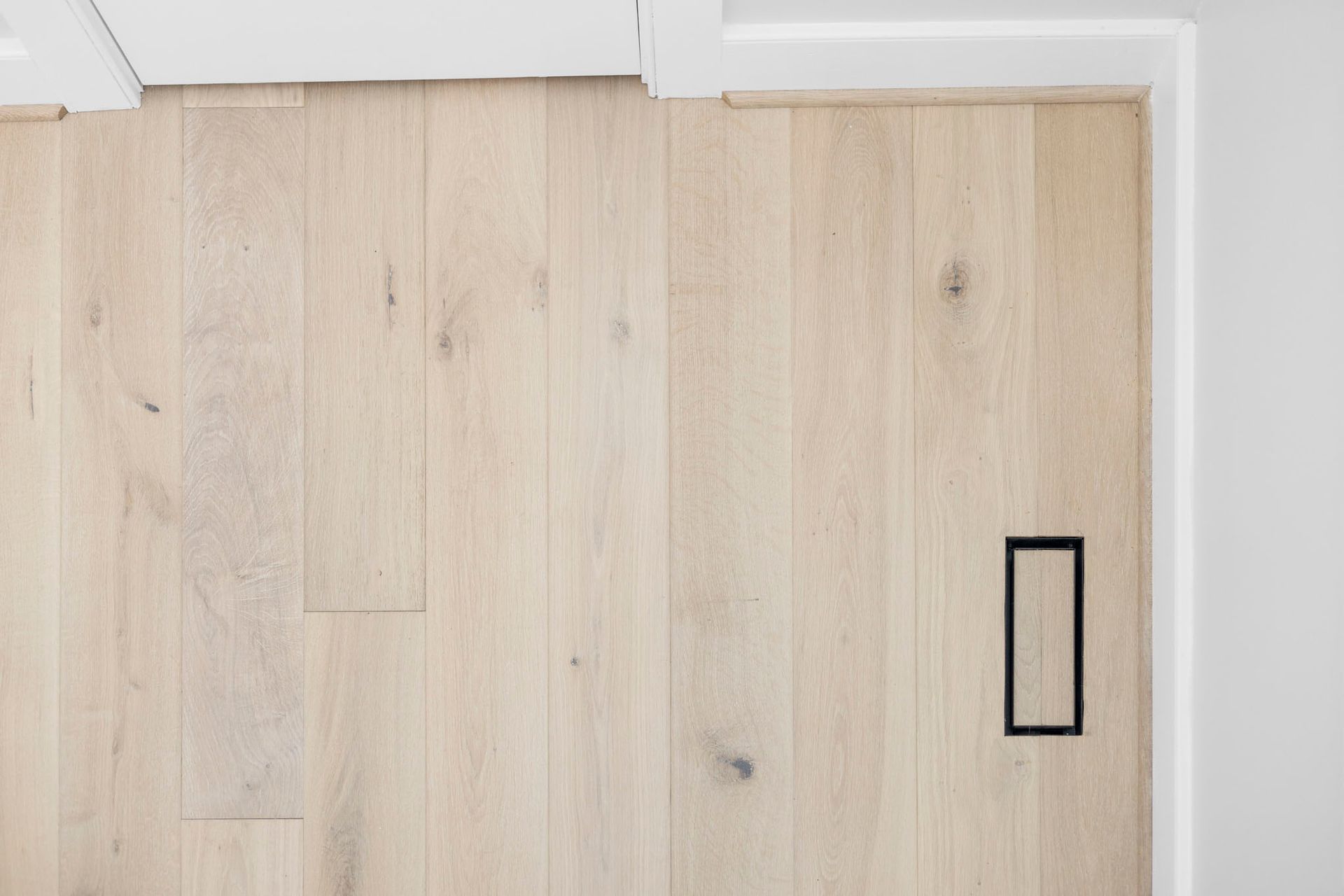 Light wood floor with a black rectangular floor outlet near the wall.