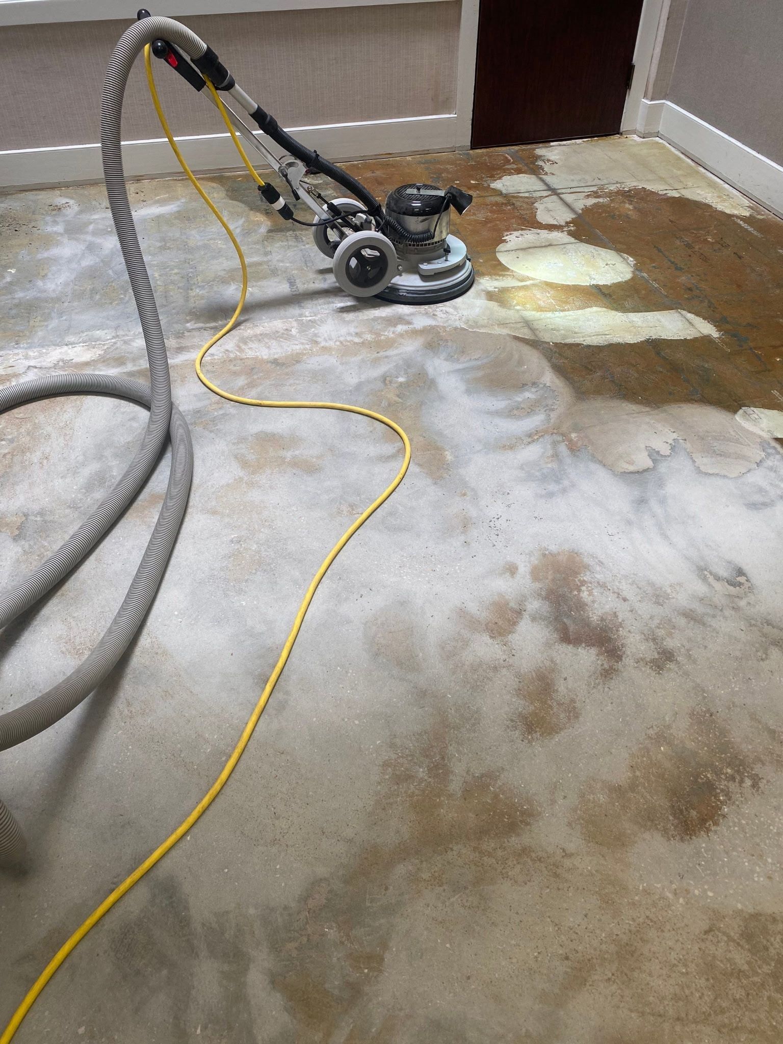 Floor buffer machine sanding a floor with cords attached