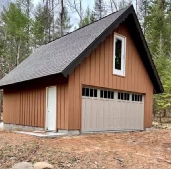 Brown wooden garage with a tan door and garage door, and a small upper window.