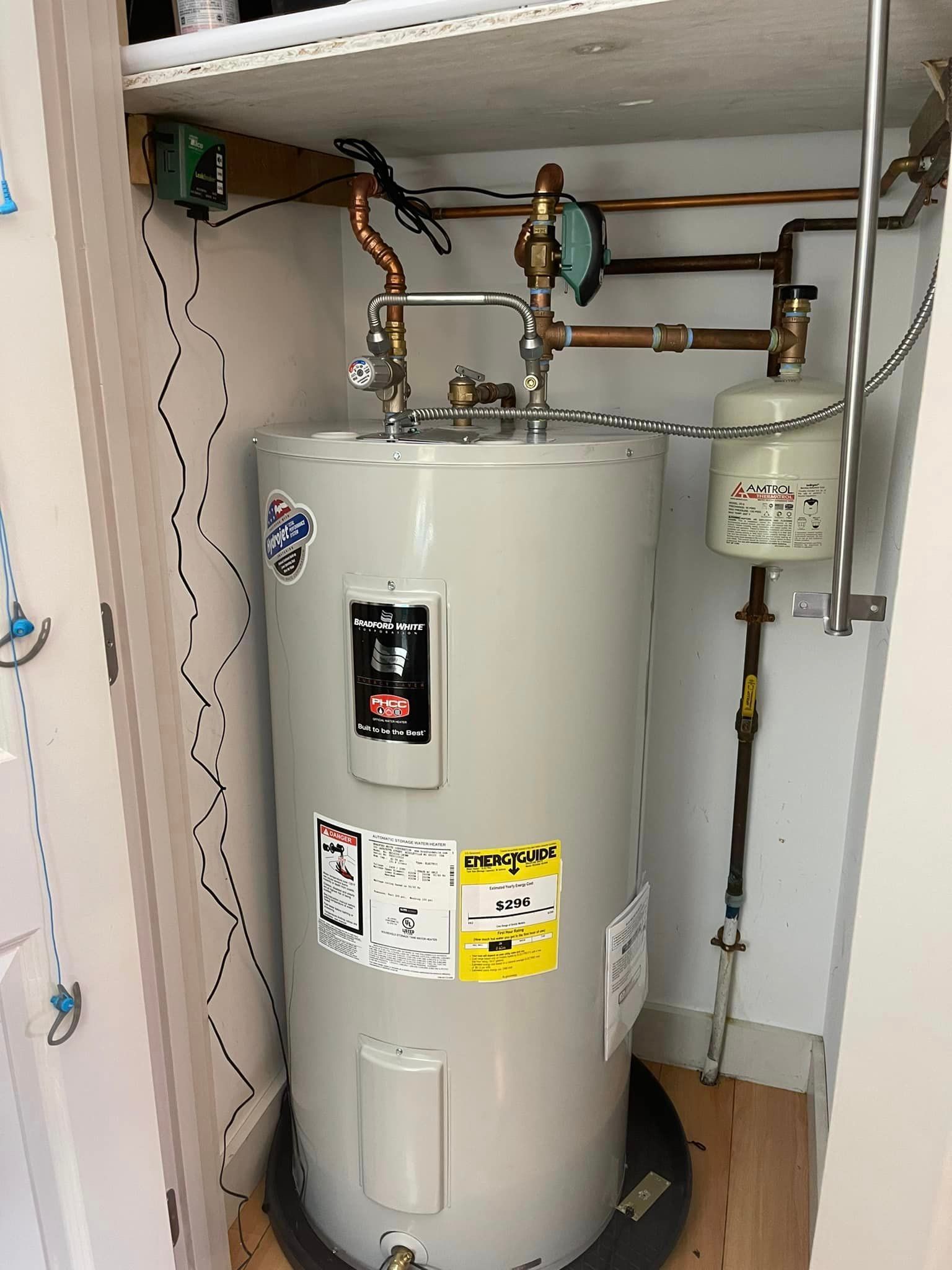 A white water heater is sitting inside of a closet.