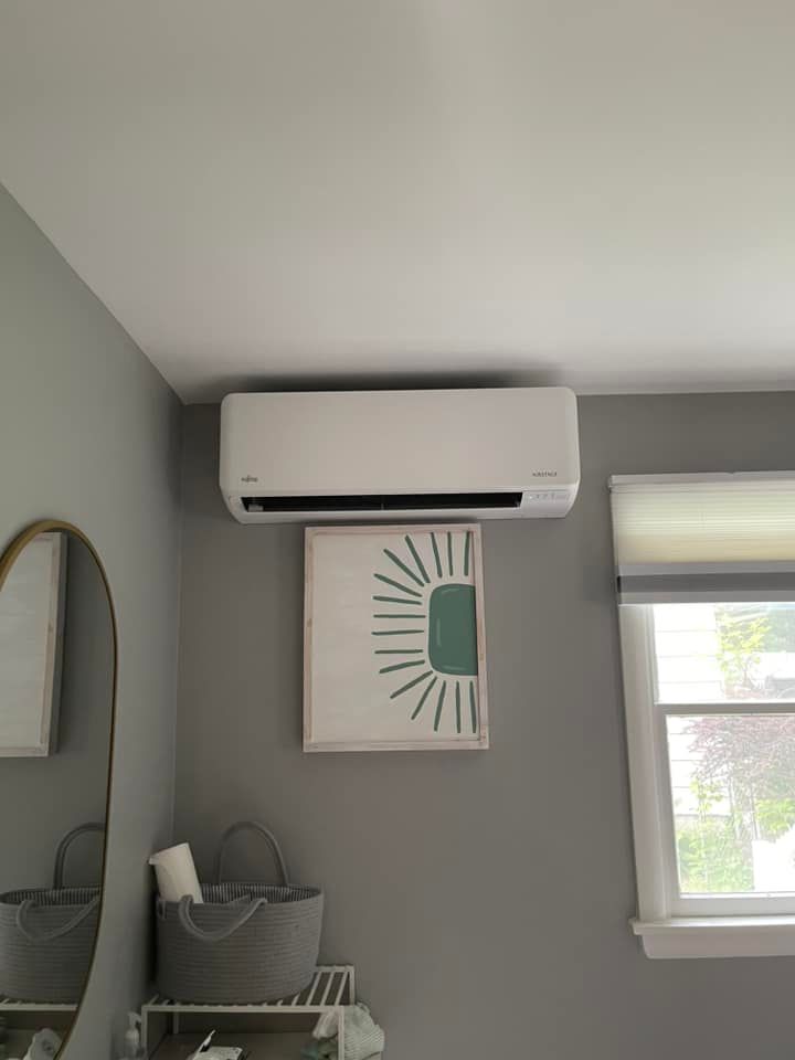 There is a picture of a sun on the wall above the air conditioner.