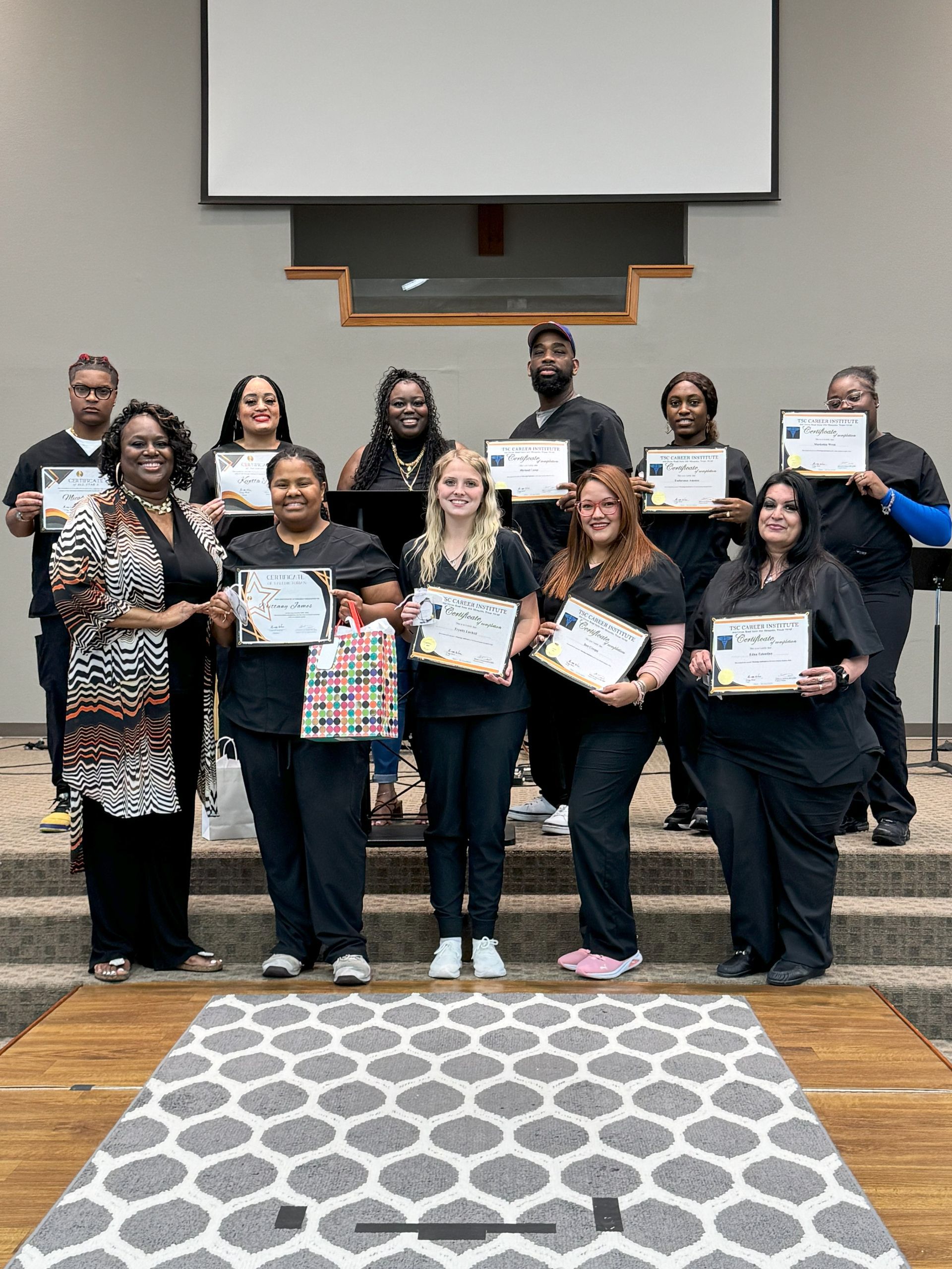 A group of people standing next to each other holding certificates.