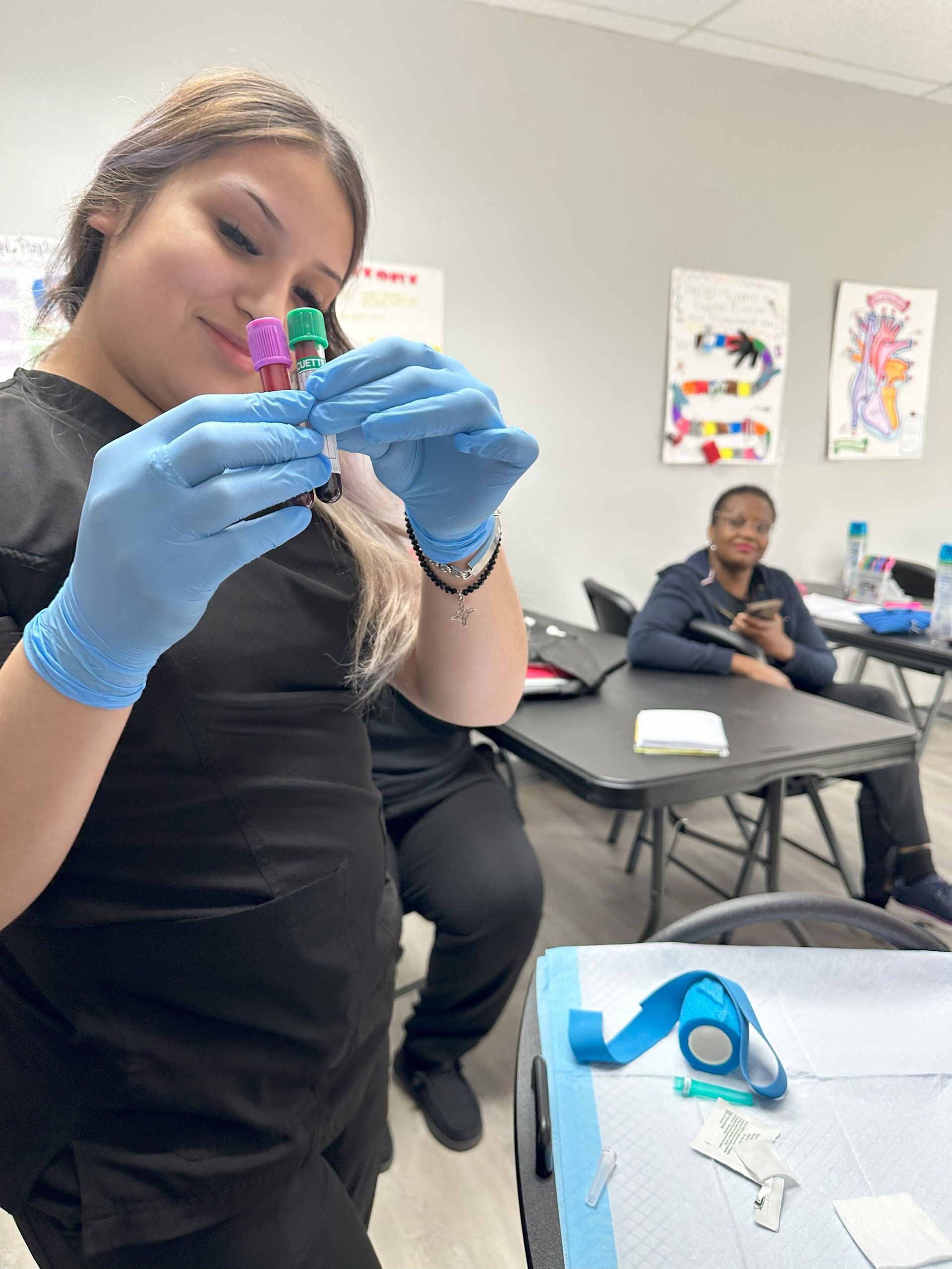 A woman holding two blood collection tubes