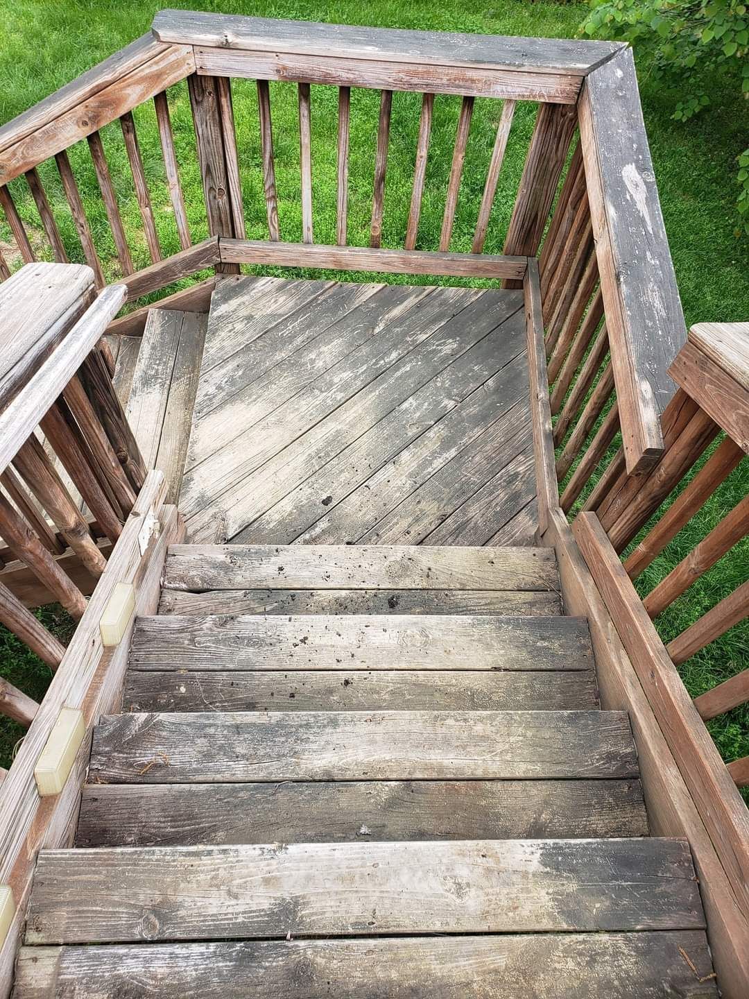 Wooden outdoor staircase with weathered steps and railings.