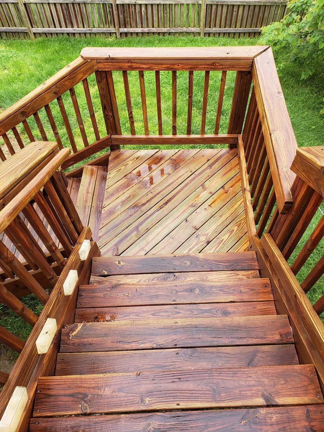 Wooden outdoor deck stairs leading down, stained dark brown.
