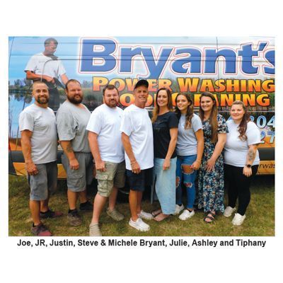 Group of people standing in front of a power washing truck with their names beneath.