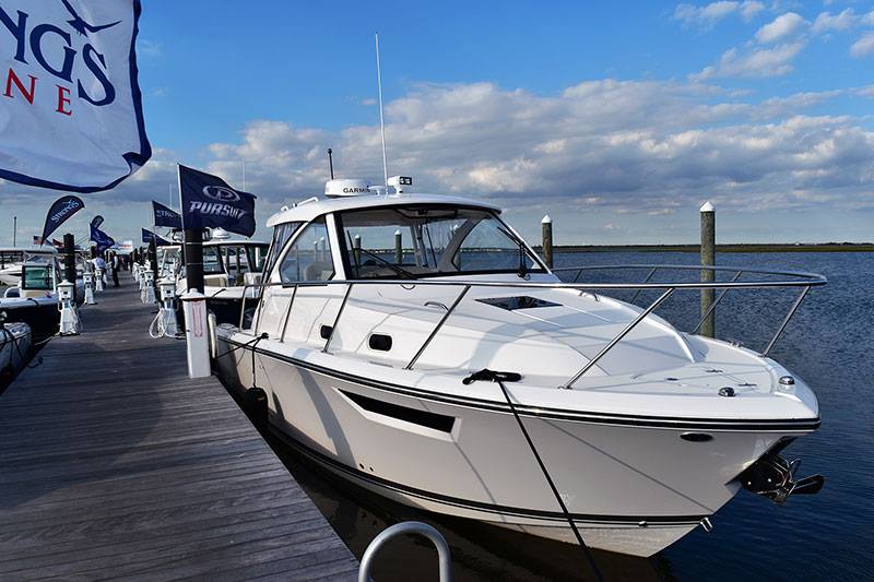 A white boat is docked at a dock with a flag that says wings on it.