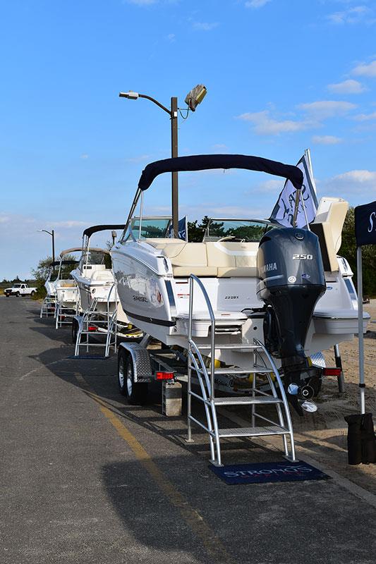 A row of boats are parked on the side of the road.