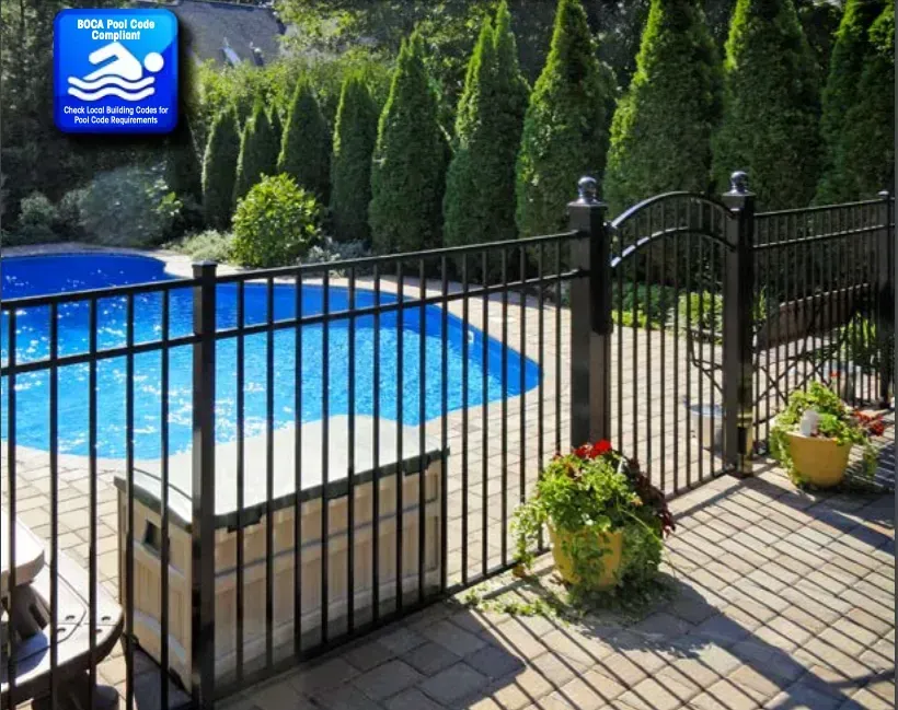 Black fence around a blue pool on a sunny patio, with gate and potted plants.
